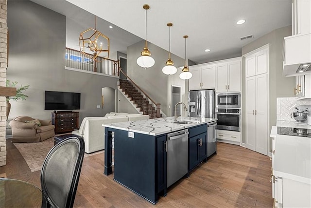 21410 W 189th Ter, Spring Hill, KS 66083 - kitchen featuring stainless steel appliances, a sink, white cabinets, wood finished floors, and recessed lighting