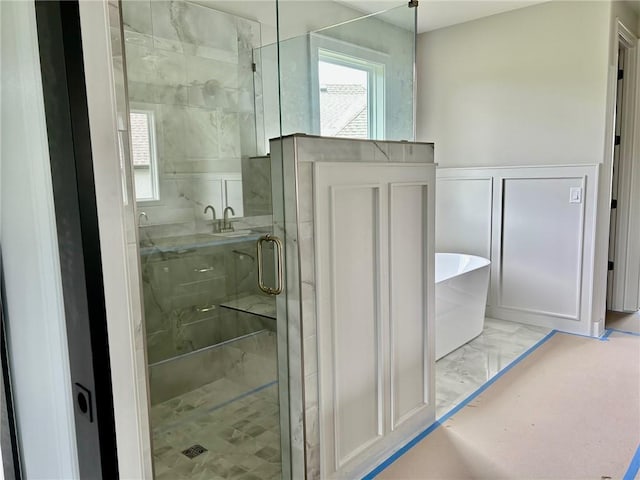 10303 W 151st Ter, Overland Park, KS 66221 - full bathroom with marble look tile flooring, a freestanding bath, and a stall shower