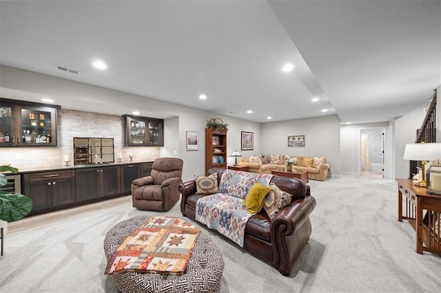 living room with light carpet, recessed lighting, and bar