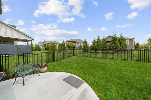 view of yard featuring a patio, ceiling fan, and a residential view