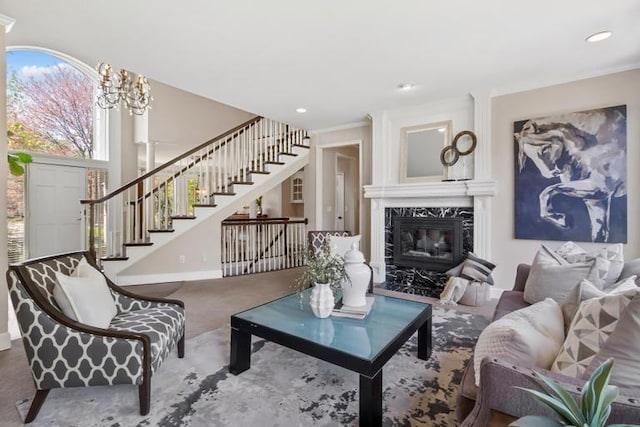 carpeted living area featuring baseboards, recessed lighting, a premium fireplace, and stairway