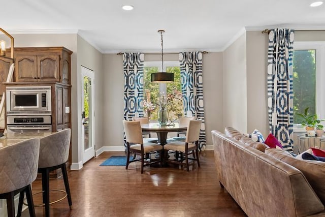 dining room featuring baseboards, ornamental molding, a wealth of natural light, and dark wood-type flooring