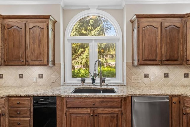 kitchen with light stone counters, a sink, decorative backsplash, and dishwasher