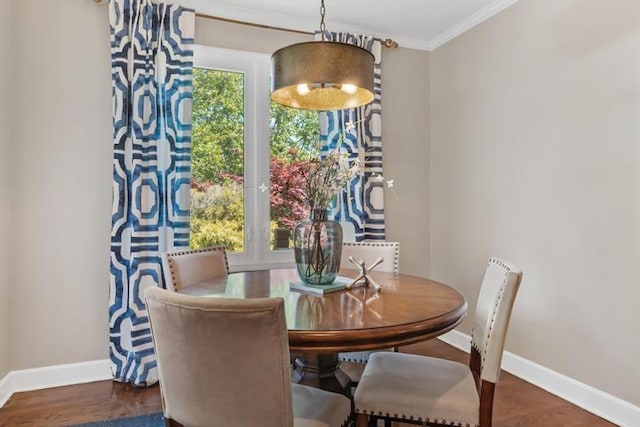 dining room with baseboards, crown molding, and wood finished floors