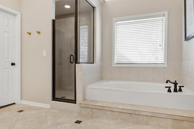 bathroom with tile patterned floors, a shower stall, and a garden tub