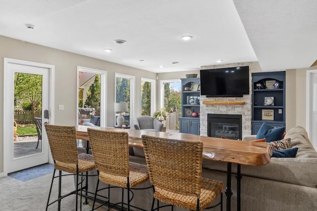 dining room featuring plenty of natural light, recessed lighting, light carpet, and a fireplace