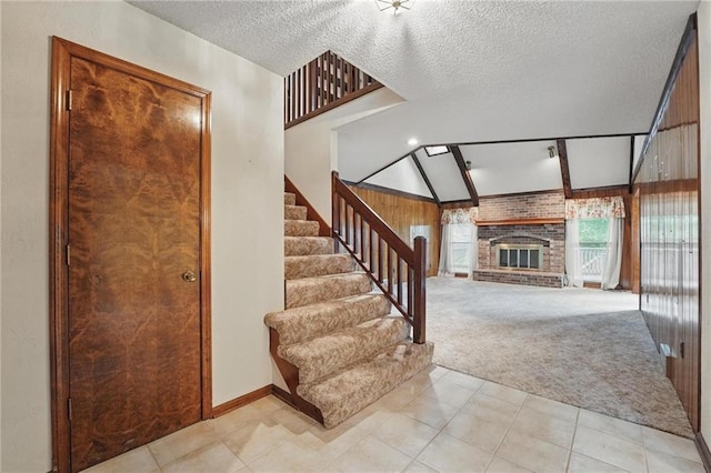 10503 W 50th Ter, Shawnee, KS 66203 - stairway with a fireplace, carpet flooring, a textured ceiling, baseboards, and tile patterned flooring