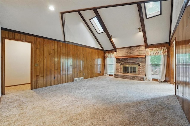 10503 W 50th Ter, Shawnee, KS 66203 - unfurnished living room with wooden walls, carpet flooring, a brick fireplace, and a skylight