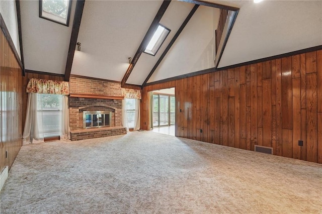 10503 W 50th Ter, Shawnee, KS 66203 - unfurnished living room featuring beamed ceiling, carpet, wooden walls, a brick fireplace, and high vaulted ceiling