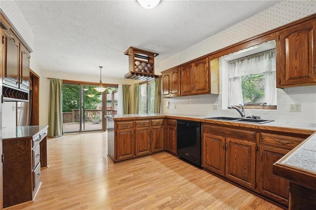10503 W 50th Ter, Shawnee, KS 66203 - kitchen with dishwasher, a sink, a peninsula, light wood-style flooring, and light countertops