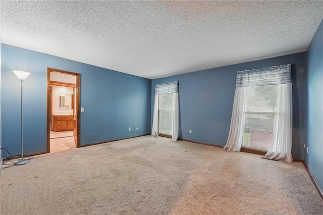 10503 W 50th Ter, Shawnee, KS 66203 - unfurnished bedroom featuring carpet, a textured ceiling, ensuite bath, and baseboards
