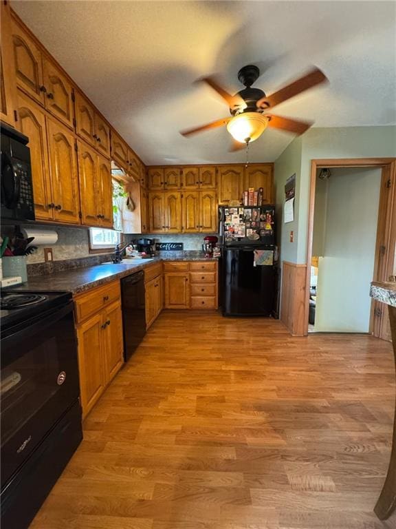 166 Crescent Dr, Chillicothe, MO 64601 - kitchen with brown cabinets, dark countertops, ceiling fan, and black appliances