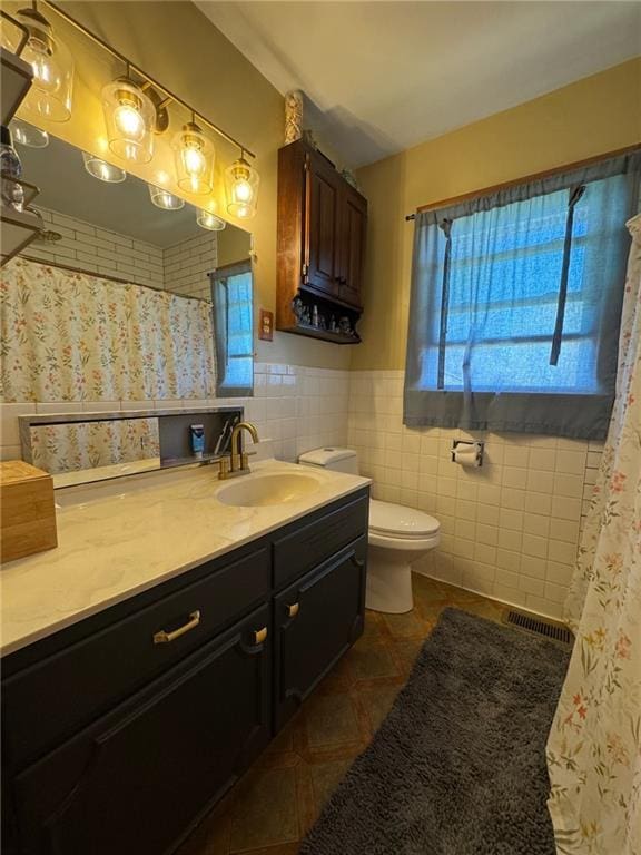 166 Crescent Dr, Chillicothe, MO 64601 - full bath with tile patterned floors, vanity, tile walls, toilet, and visible vents