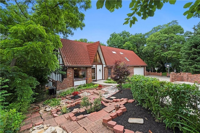 4710 Monrovia St, Shawnee, KS 66216 - back of house featuring a tile roof, brick siding, and a garage