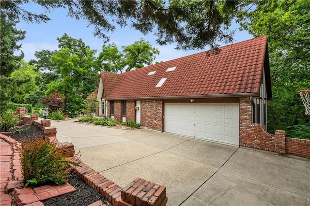 4710 Monrovia St, Shawnee, KS 66216 - view of property exterior with a tile roof, brick siding, driveway, and a garage