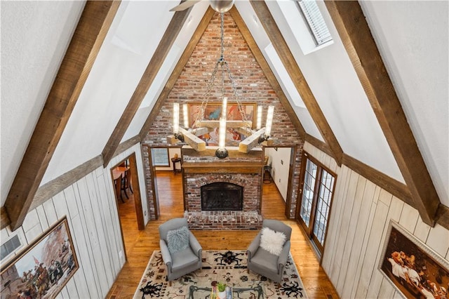 4710 Monrovia St, Shawnee, KS 66216 - living room with high vaulted ceiling, a fireplace, wood finished floors, beamed ceiling, and wood walls