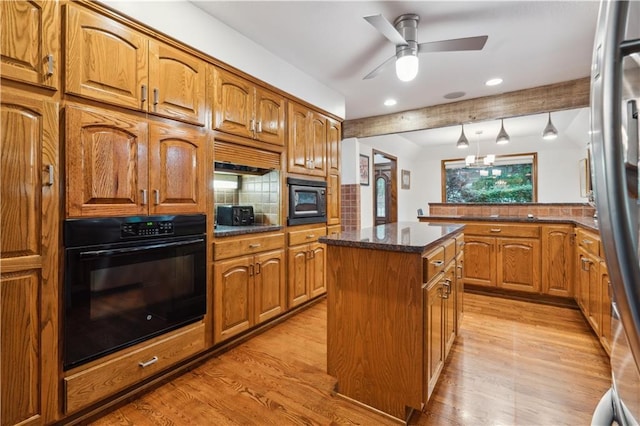 4710 Monrovia St, Shawnee, KS 66216 - kitchen with black appliances, light wood-style flooring, brown cabinets, a center island, and recessed lighting