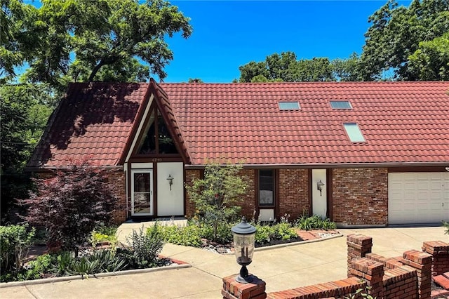 4710 Monrovia St, Shawnee, KS 66216 - view of front facade with a tile roof, a garage, and brick siding