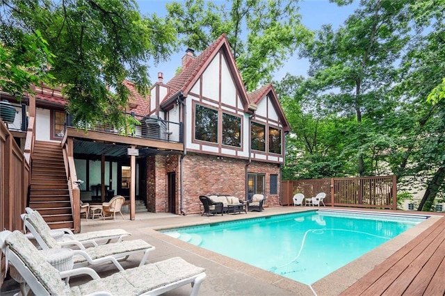 4710 Monrovia St, Shawnee, KS 66216 - outdoor pool with a wooden deck, stairs, a patio, and an outdoor hangout area
