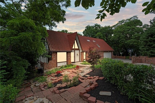 4710 Monrovia St, Shawnee, KS 66216 - view of front facade featuring a tiled roof, brick siding, and an attached garage