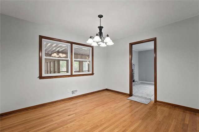 8416 Westridge Rd, Raytown, MO 64138 - unfurnished room with light wood finished floors, visible vents, a notable chandelier, and baseboards