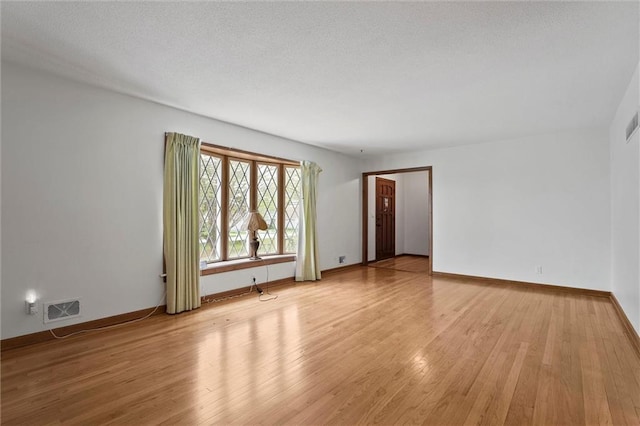 8416 Westridge Rd, Raytown, MO 64138 - unfurnished living room with visible vents, baseboards, and light wood-style floors