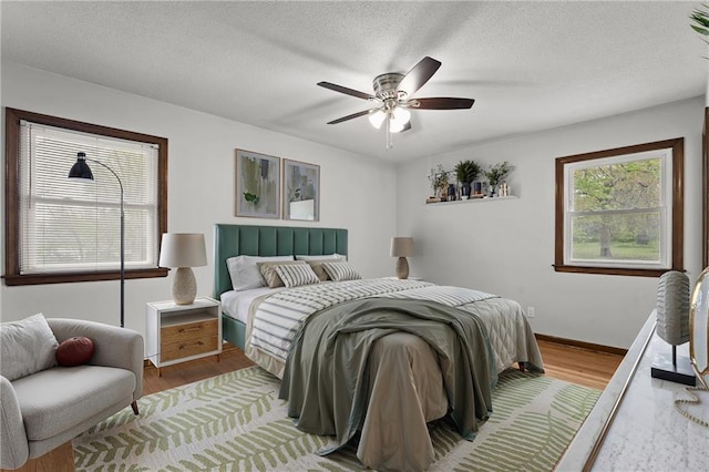8416 Westridge Rd, Raytown, MO 64138 - bedroom with wood finished floors, ceiling fan, and baseboards