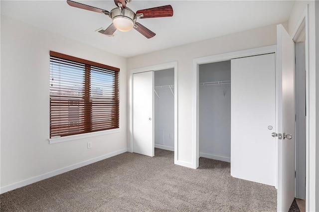 4581 Madison Ave, Kansas City, MO 64111 - unfurnished bedroom with multiple closets, light carpet, baseboards, and a ceiling fan