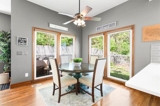 dining area featuring visible vents, ceiling fan, wood finished floors, and plenty of natural light