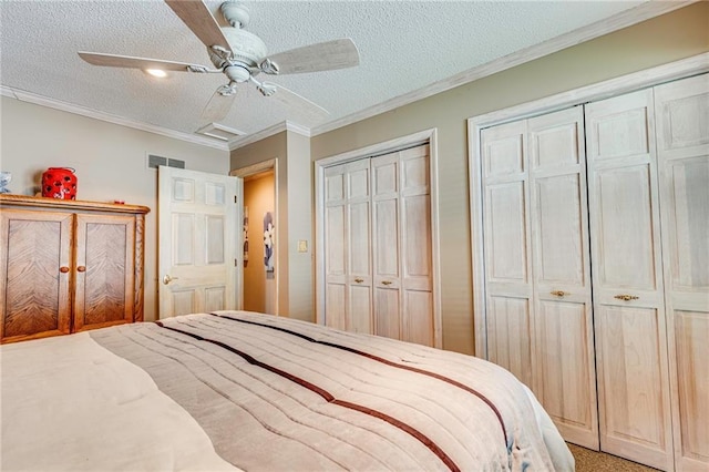 521 W Sugar Lake Dr, Mound City, KS 66056 - carpeted bedroom with two closets, ornamental molding, a textured ceiling, and a ceiling fan