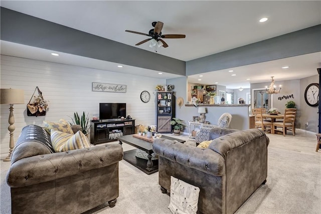 living area featuring recessed lighting, light carpet, and ceiling fan with notable chandelier