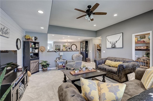 living area featuring baseboards, ceiling fan with notable chandelier, recessed lighting, and light colored carpet
