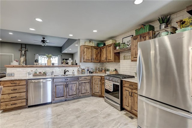 kitchen with ceiling fan, a sink, stainless steel appliances, recessed lighting, and decorative backsplash