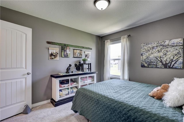 bedroom with carpet floors, baseboards, and a textured ceiling
