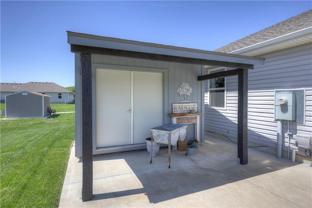 view of exterior entry with a yard and a patio area