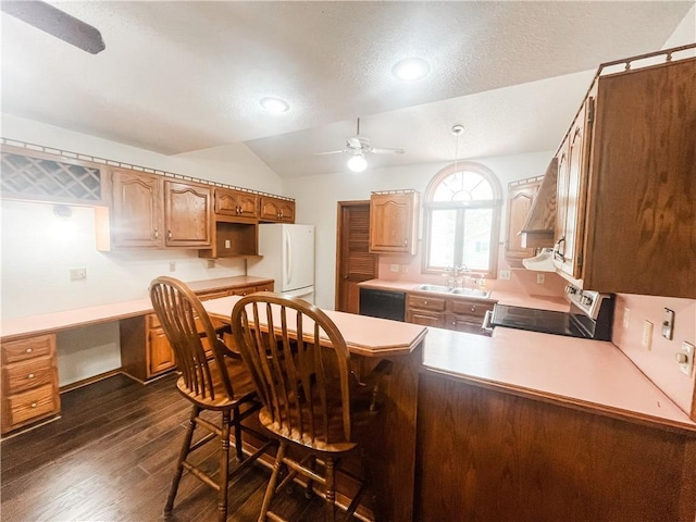 628 S Clay St, Nevada, MO 64772 - kitchen featuring a ceiling fan, range, a sink, freestanding refrigerator, and a peninsula