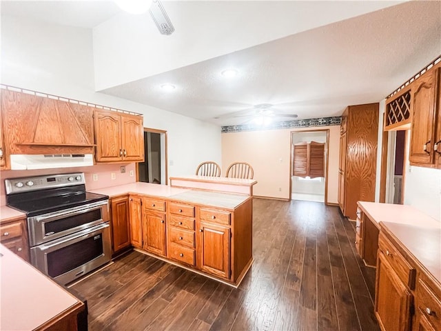 628 S Clay St, Nevada, MO 64772 - kitchen with a peninsula, ceiling fan, light countertops, under cabinet range hood, and double oven range