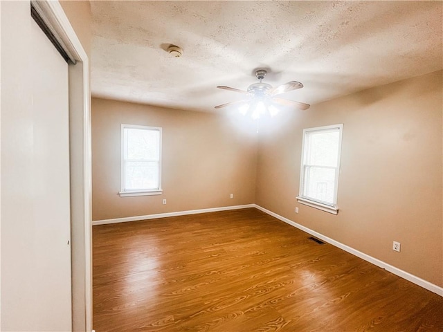 628 S Clay St, Nevada, MO 64772 - unfurnished room with ceiling fan, a textured ceiling, visible vents, wood finished floors, and baseboards
