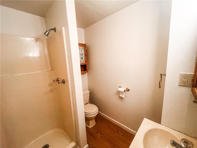 628 S Clay St, Nevada, MO 64772 - full bath with toilet, a sink, a shower stall, and wood finished floors
