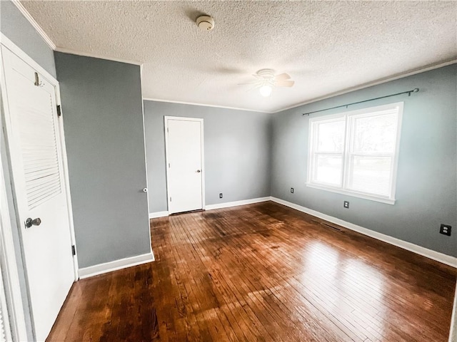 628 S Clay St, Nevada, MO 64772 - unfurnished bedroom featuring crown molding, a textured ceiling, baseboards, and hardwood / wood-style floors