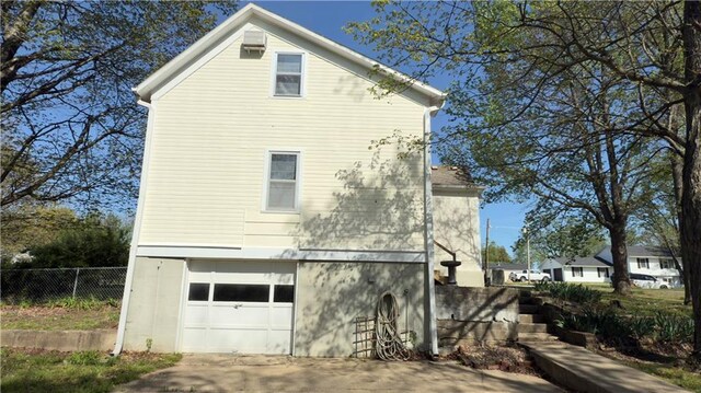 628 S Clay St, Nevada, MO 64772 - view of property exterior with an attached garage, fence, and concrete driveway