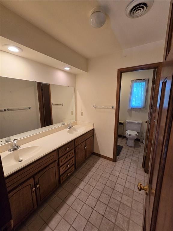 1502 Hillcrest Ct, Atchison, KS 66002 - bathroom with tile patterned floors, toilet, double vanity, and baseboards
