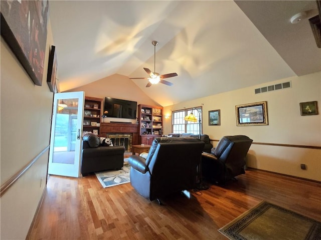 1502 Hillcrest Ct, Atchison, KS 66002 - living area with light wood-style flooring, a ceiling fan, a fireplace, vaulted ceiling, and baseboards