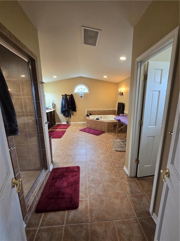 1502 Hillcrest Ct, Atchison, KS 66002 - full bathroom featuring lofted ceiling, tile patterned flooring, a stall shower, and a garden tub