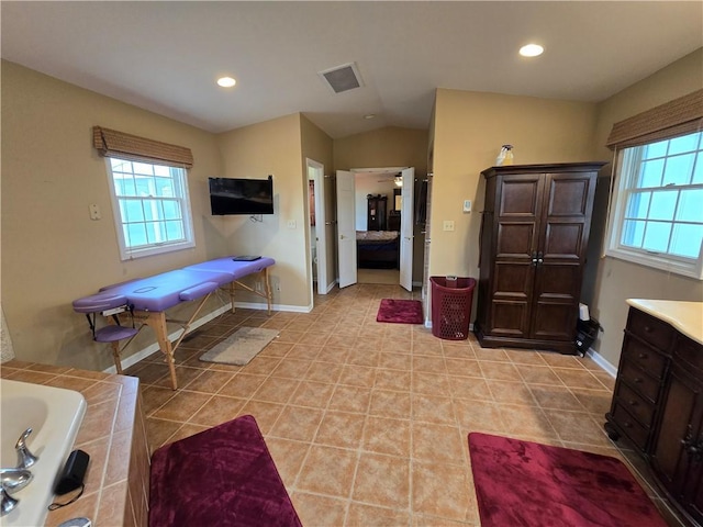 1502 Hillcrest Ct, Atchison, KS 66002 - ensuite bathroom featuring tile patterned floors, vaulted ceiling, recessed lighting, baseboards, and a tub to relax in