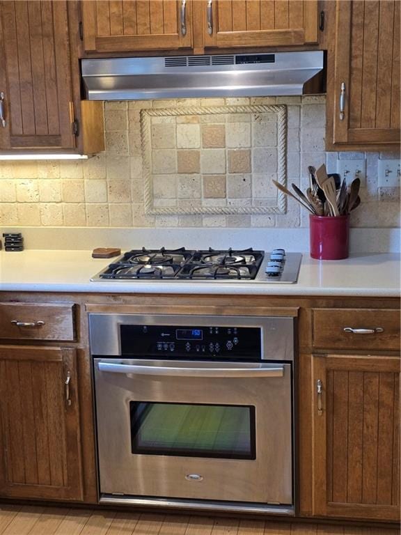 1502 Hillcrest Ct, Atchison, KS 66002 - kitchen featuring stainless steel appliances, under cabinet range hood, decorative backsplash, and light countertops
