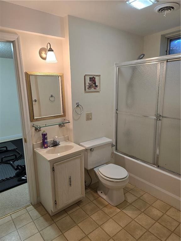 1502 Hillcrest Ct, Atchison, KS 66002 - bathroom featuring tile patterned flooring, vanity, toilet, and bath / shower combo with glass door