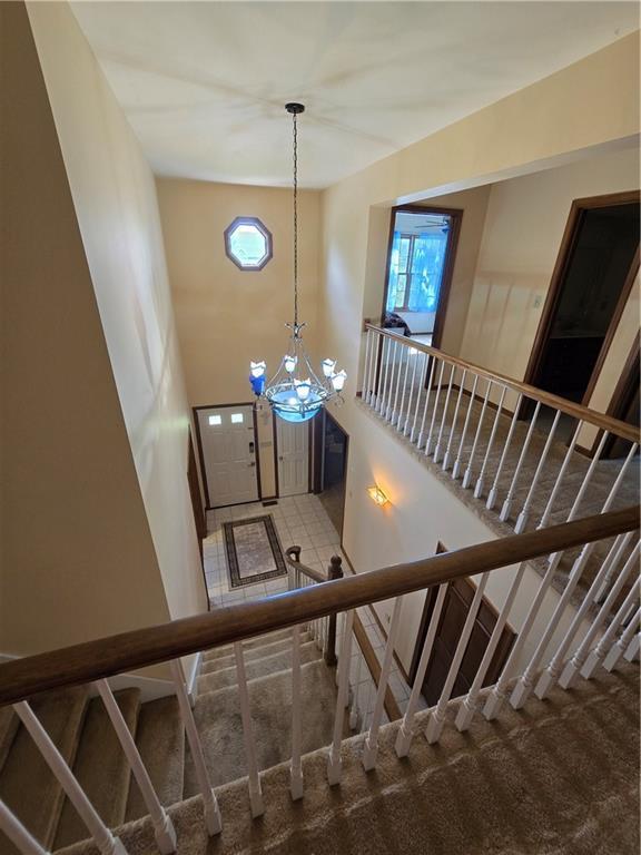 1502 Hillcrest Ct, Atchison, KS 66002 - stairs featuring plenty of natural light, a chandelier, and carpet