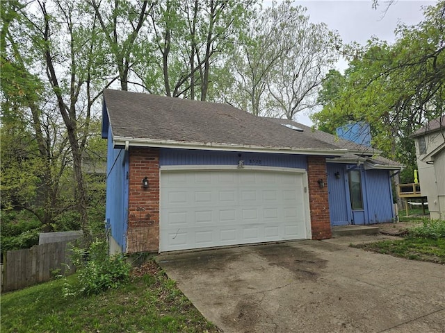 view of front facade featuring driveway, an attached garage, fence, and brick siding