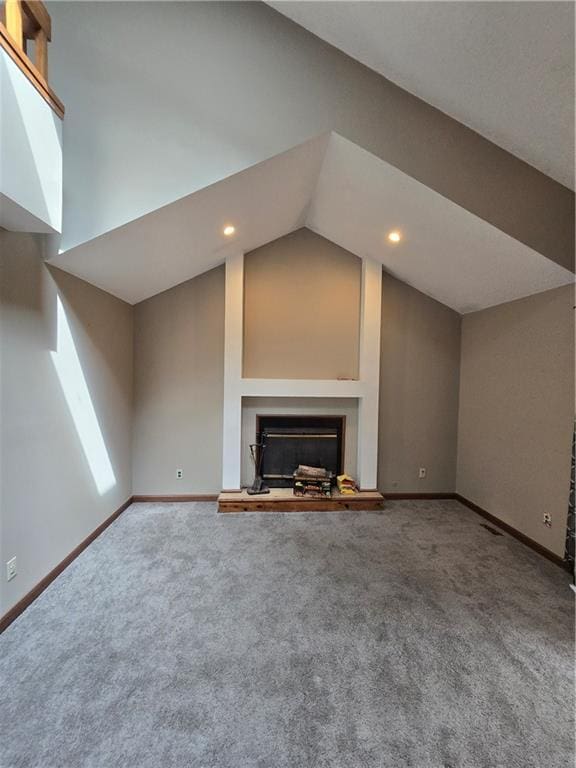 unfurnished living room featuring carpet flooring, baseboards, and a fireplace with raised hearth